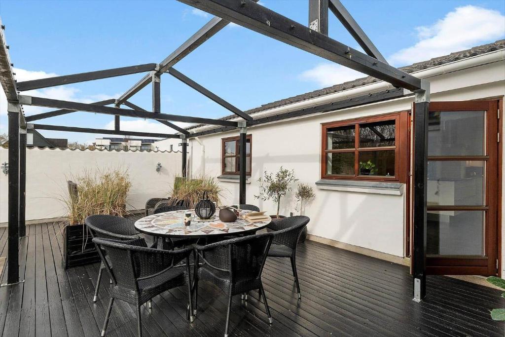 un patio con tavolo e sedie su un ponte di HA370-Saeby-H-C-Gads-Vej-5 a Sæby