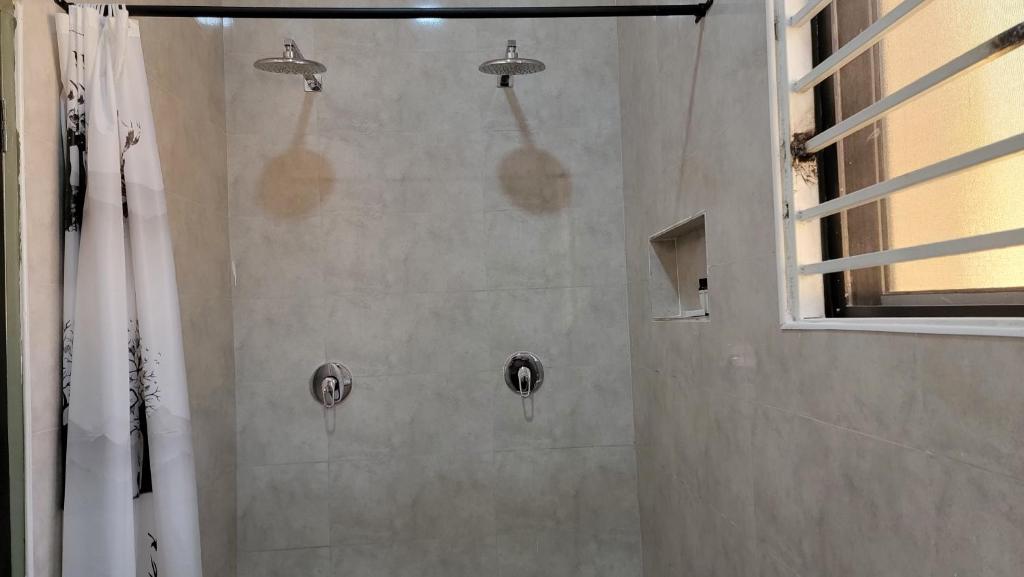 y baño con ducha y 2 cabezales de ducha. en Mahanaim Luxury apartments, en Lusaka