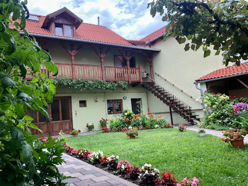 a house with a balcony and a yard with flowers at CASA Maria in Orlat