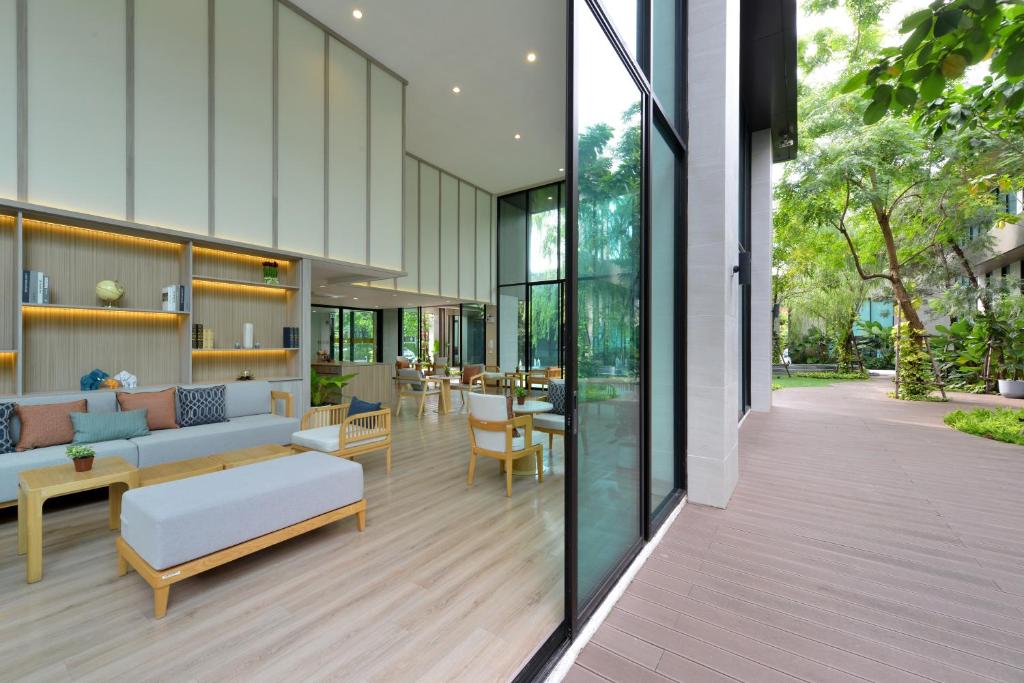 A light-filled lounge leads through glass doors to a landscaped outdoor deck.