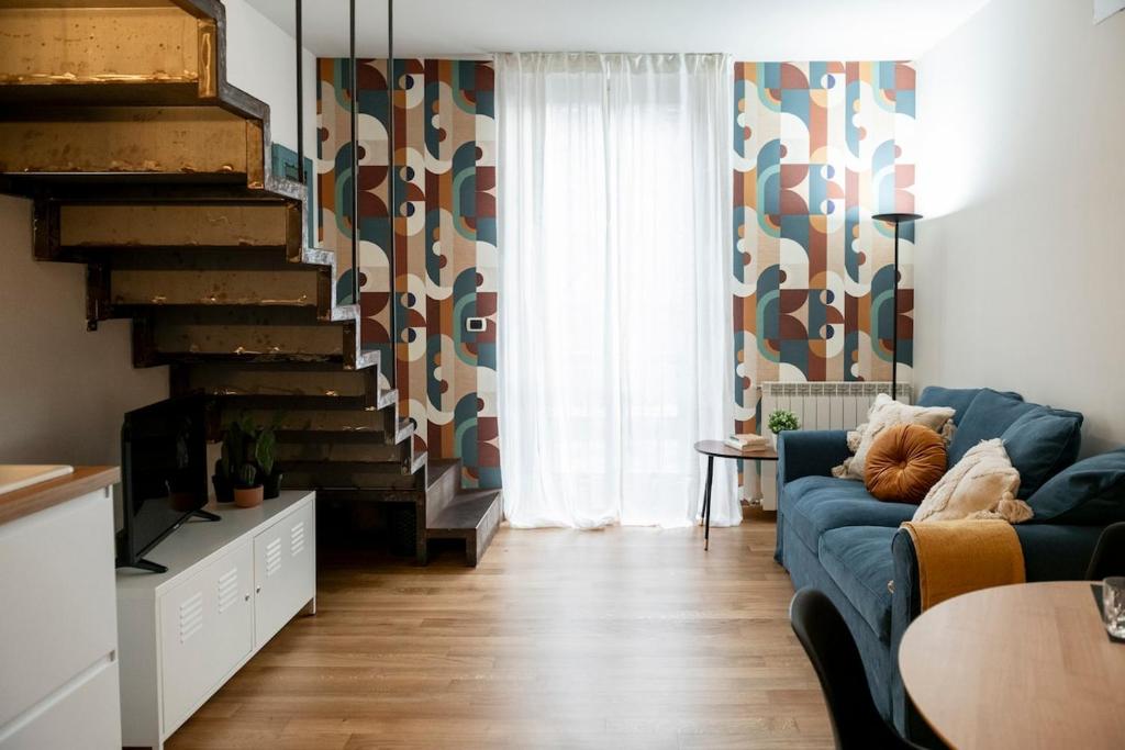 a living room with a blue couch and a staircase at Regina 144 by RD Domus in Turin