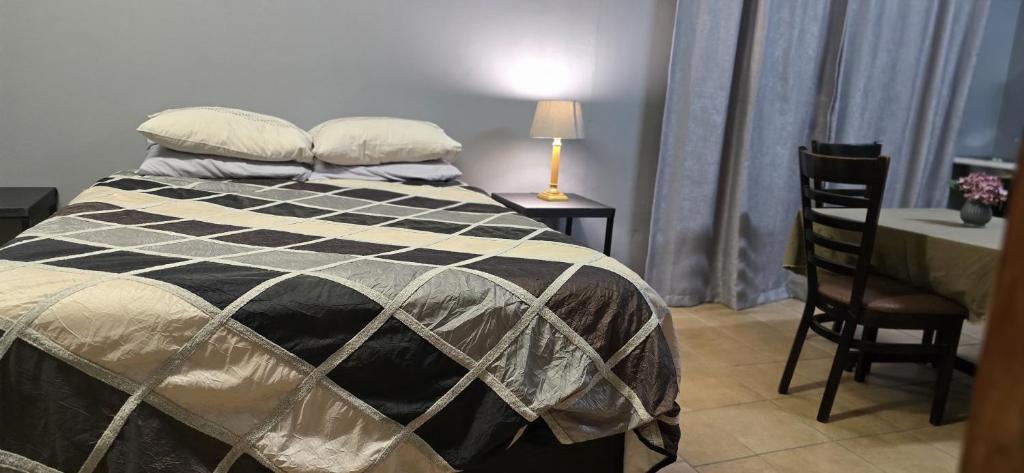 een slaapkamer met een bed, een tafel en stoelen bij Yoruville in Rustenburg