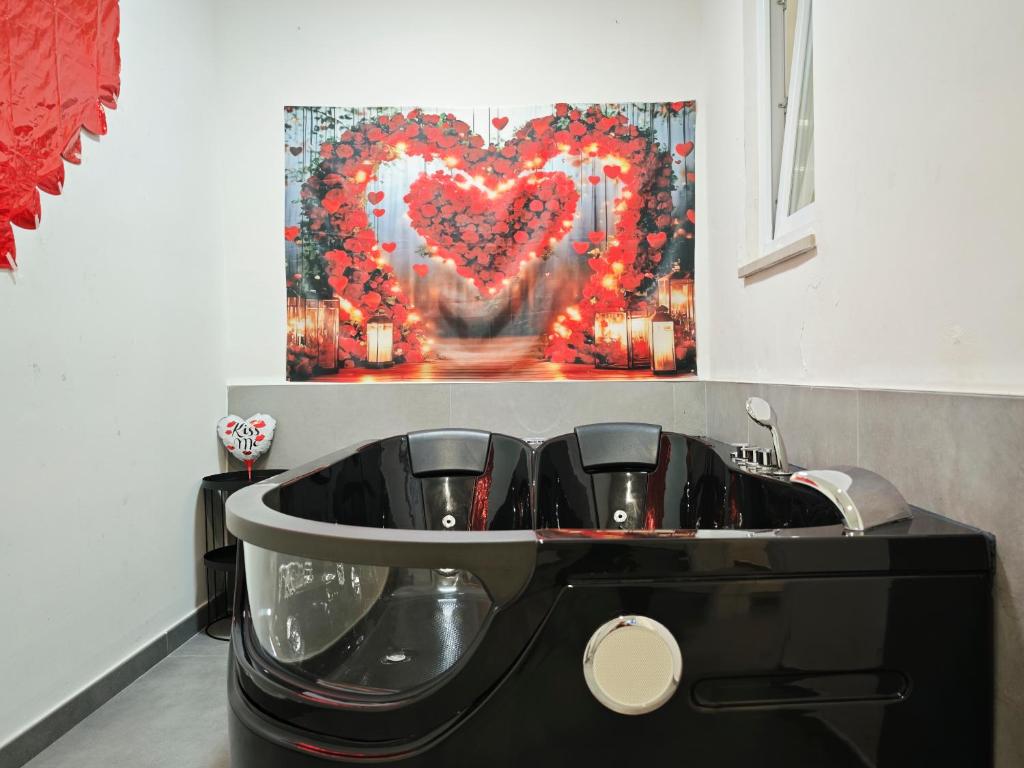 un bagno con una vasca con un dipinto a forma di cuore sul muro di Raggio di Sole 3 a Bari