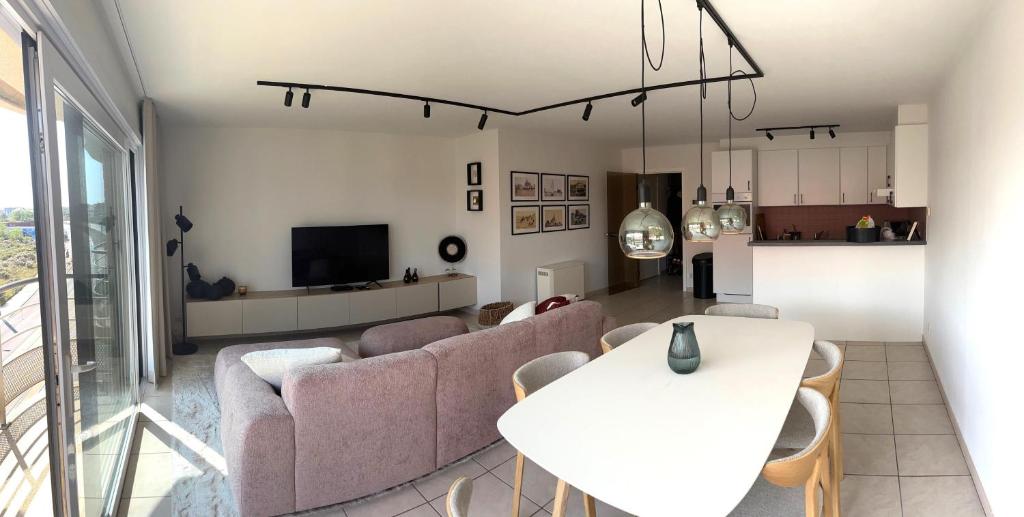 a living room with a couch and a table at Beachside Family Apartment Windstar 402 in Oostduinkerke