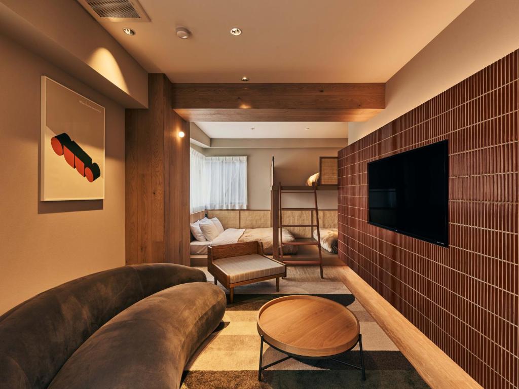 a living room with a large couch and a flat screen tv at illi Mia Kinshicho in Tokyo