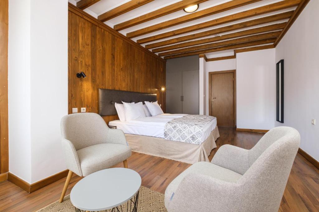 a bedroom with a bed and two chairs at Hotel Razlog in Razlog