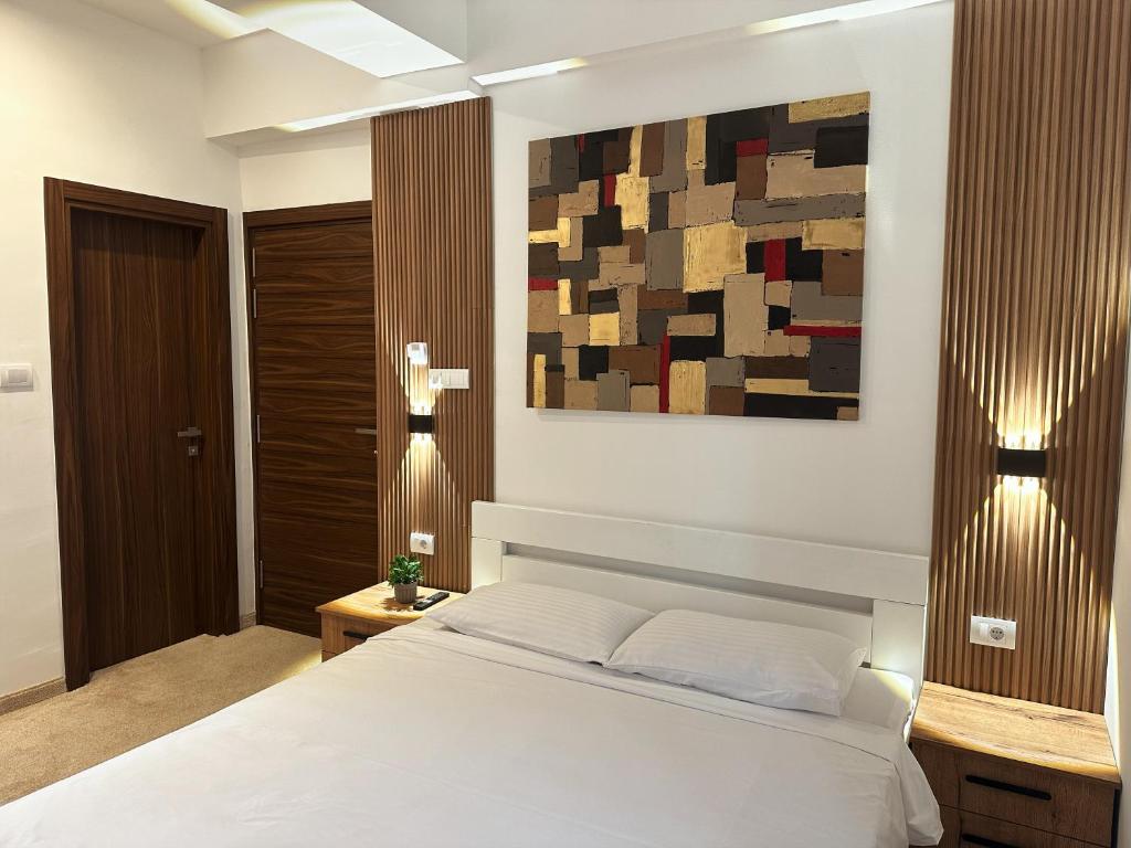 a bedroom with a bed and a painting on the wall at Hillside Garden by Sienna in Skopje