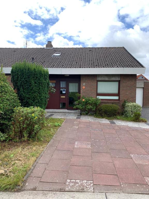 a house with a brick driveway in front of it at Ferienhaus Strandlöper Reiners in Horumersiel