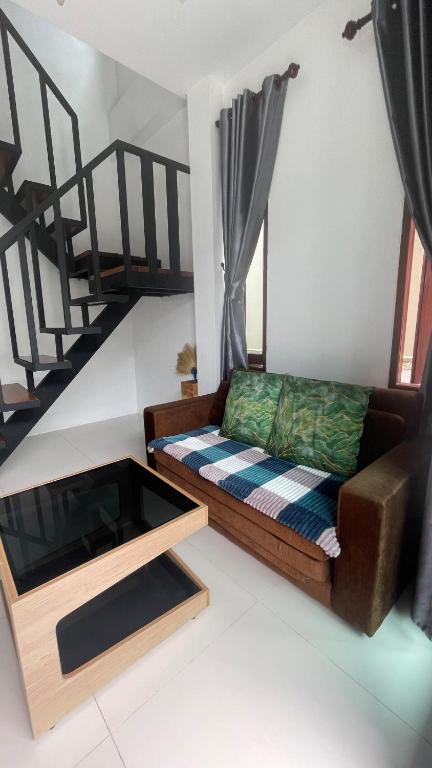 a living room with a couch and a staircase at Happy House in Chaloklum in Chaloklum
