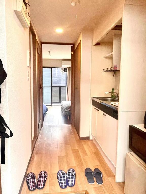 dos pares de zapatillas en el suelo de una cocina en Tokyo West Shinjuku close to Shinjuku Chuo Park, en Tokio