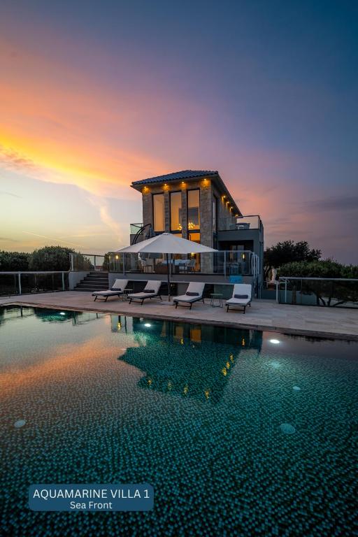 a villa with a swimming pool at sunset at Seacrete villas in Chania