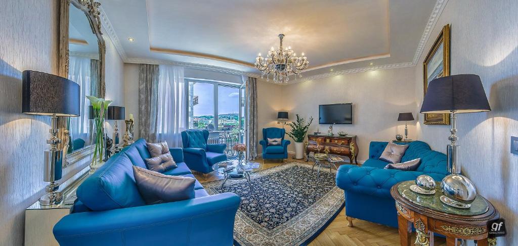 een woonkamer met blauwe meubels en een kroonluchter bij BP Residence Budapest in Boedapest