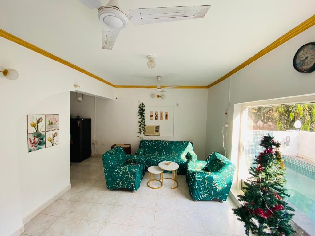 a living room with two chairs and a christmas tree at Villa Greek Baga 4Bhk Villa with private Pool & Kitchen in Calangute