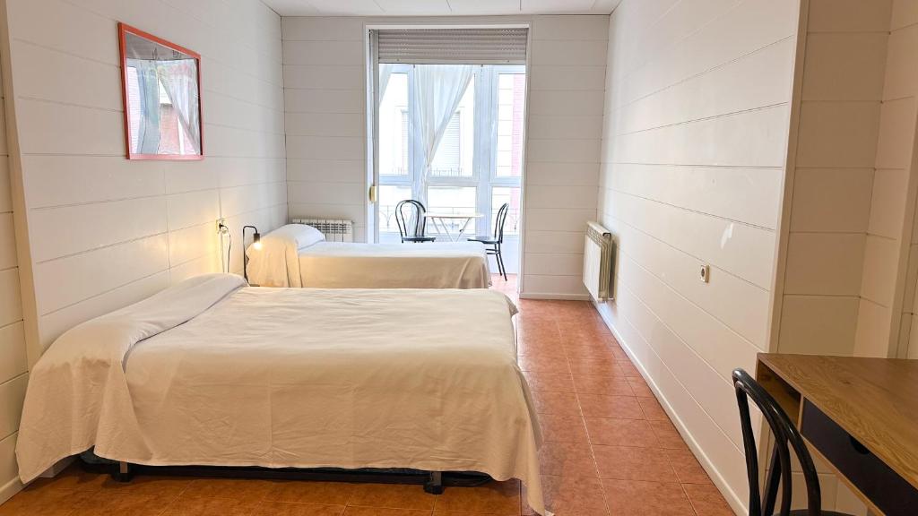 ビトリア・ガステイスにあるPension Casa 400の窓のある小さな部屋にベッドが2つある