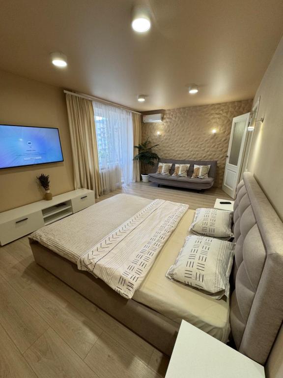 1 dormitorio grande con 1 cama grande y TV de pantalla plana en Entuziast, en Chernivtsi