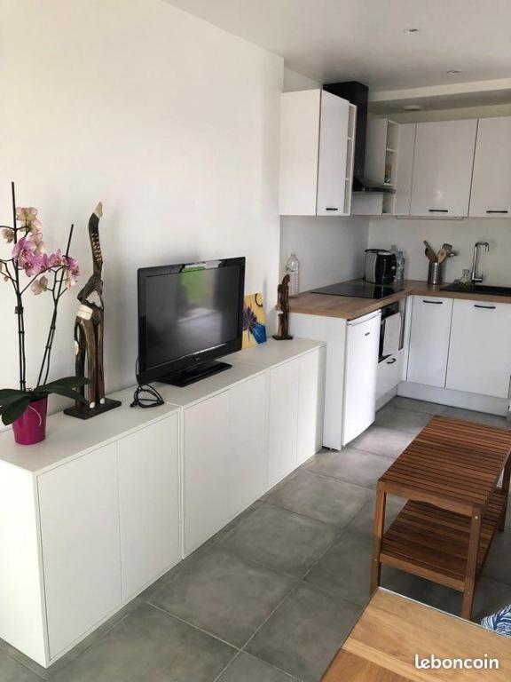 a kitchen with a flat screen tv on a counter at Le Lotus Oasis des Pins avec piscine in Labenne