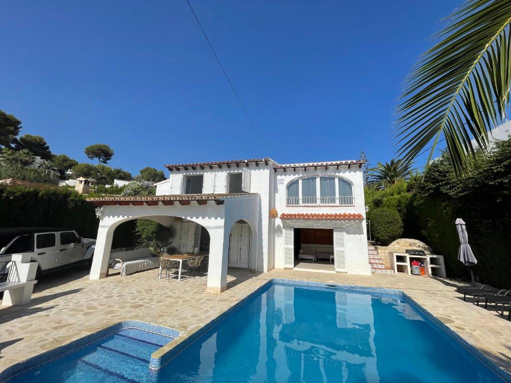 a villa with a swimming pool in front of a house at Villa Besuc Benissa Moraira 8 personnes in Benissa