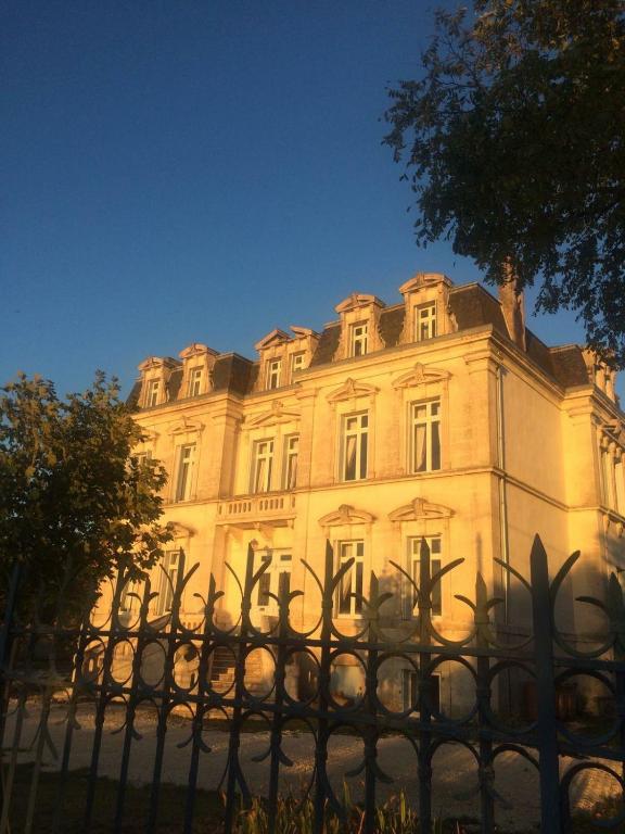 a building with a fence in front of it at Chateau de Minargent in Aulnay
