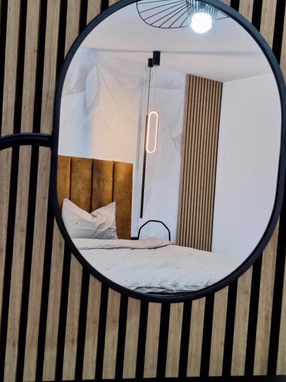 Un reflejo en el espejo de una cama en una habitación. en Ssalamandra home's, en Ocna-Mureşului