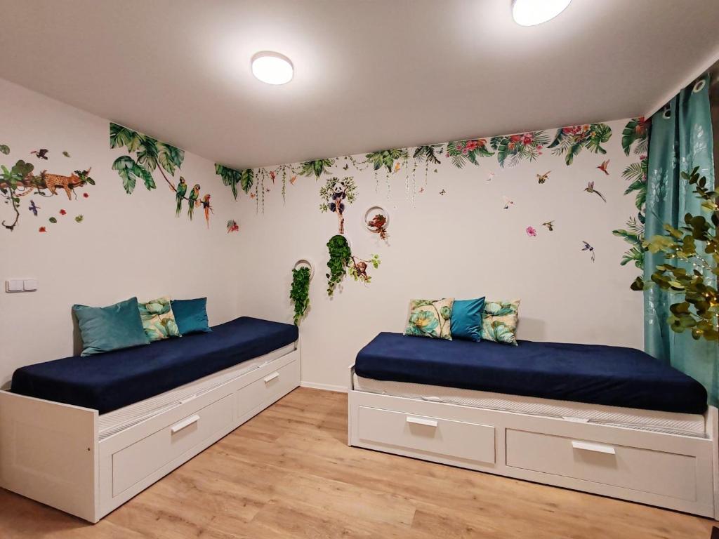 two beds in a room with flowers on the wall at Star Apartments Brno #4D415 by Starbnb EU in Brno