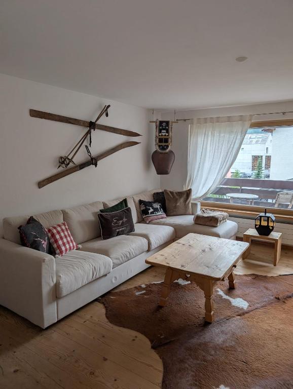 a living room with a couch and a coffee table at Wunderschöne 3 Zimmerwohnung mit Bergblick in Celerina in Celerina