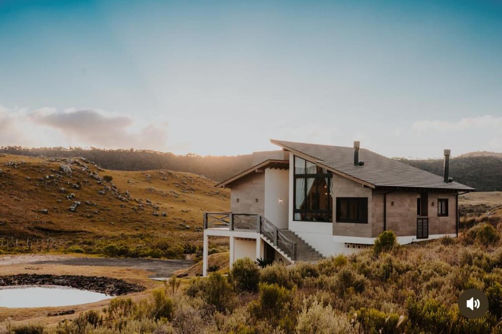 a house on the side of a hill with two ponds at Casa do Vinho- condomínio Altos da Serra in Bom Jardim da Serra