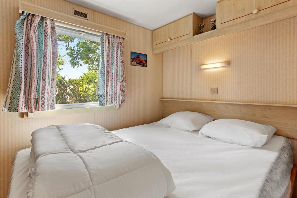 Un dormitorio con dos camas y una ventana. en Cocoon, en Sainte-Croix-du-Verdon