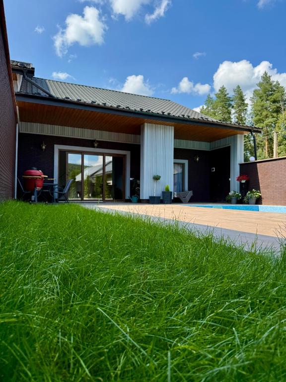 a house with a green lawn in front of it at The Selo in Korostovat