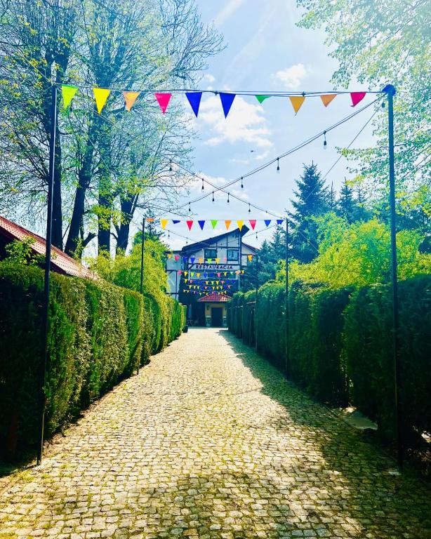 a pathway with a string of flags on a fence at Pokoje Gościnne Pod Złotym Pstrągiem in Zgorzelec