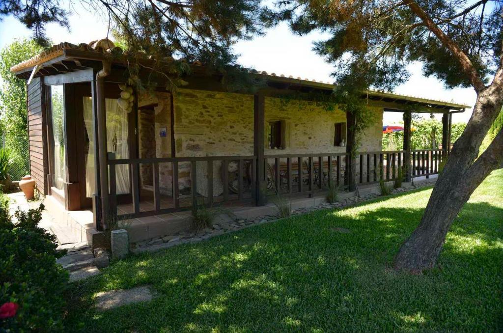 a small house with a porch and a tree at Azenha São Rafael in Ribeirão