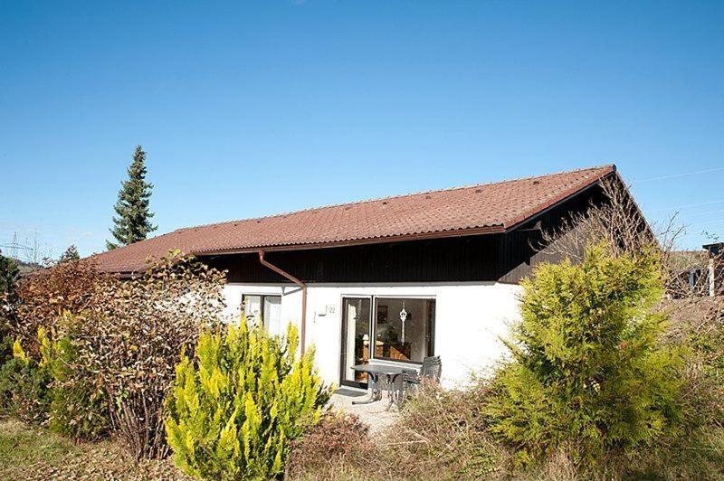 a small white house with a brown roof at Ferienhäuser Wieselweg im Feriendorf Reichenbach in Nesselwang