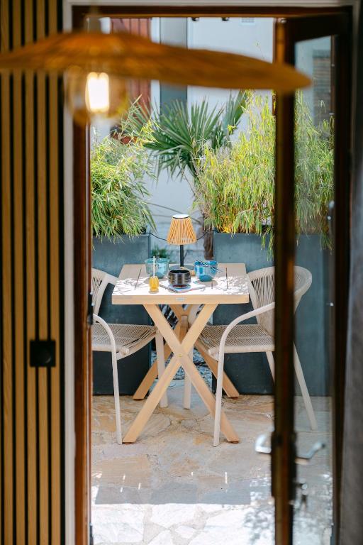 a table with a lamp and chairs on a patio at Signature Balneary, Spa & Sauna in Deauville