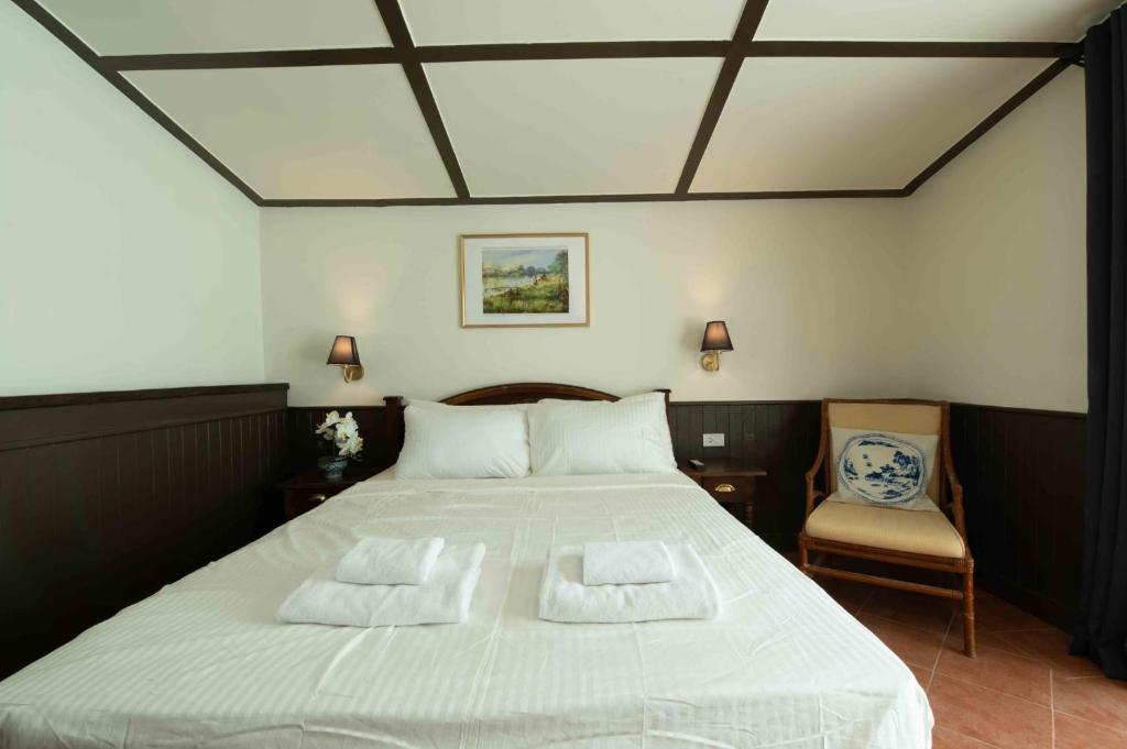 Un dormitorio con una gran cama blanca con dos almohadas. en Casa Acero, en Bangkok