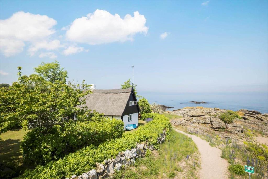 a house on a cliff next to a road at 5580-Svaneke-Mor-Markers-Gaenge-13 in Svaneke