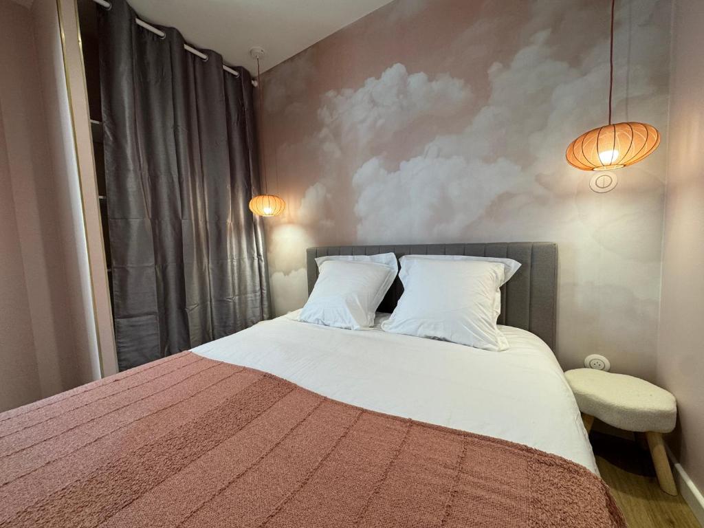 a bedroom with a large bed with two pillows at Appartement Le rêve de Gaïa Climatisation et Wifi in Moulins