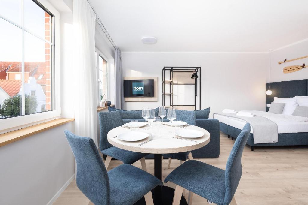 トラフェミュンデにあるApartments in der Kurgartenstraße - Altstadt - An der Vorderreiheのテーブル、椅子、ベッドが備わる客室です。