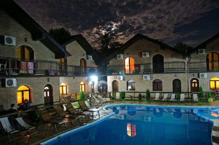 a hotel with a swimming pool in front of a building at Apartments Jeremic in Bela Crkva