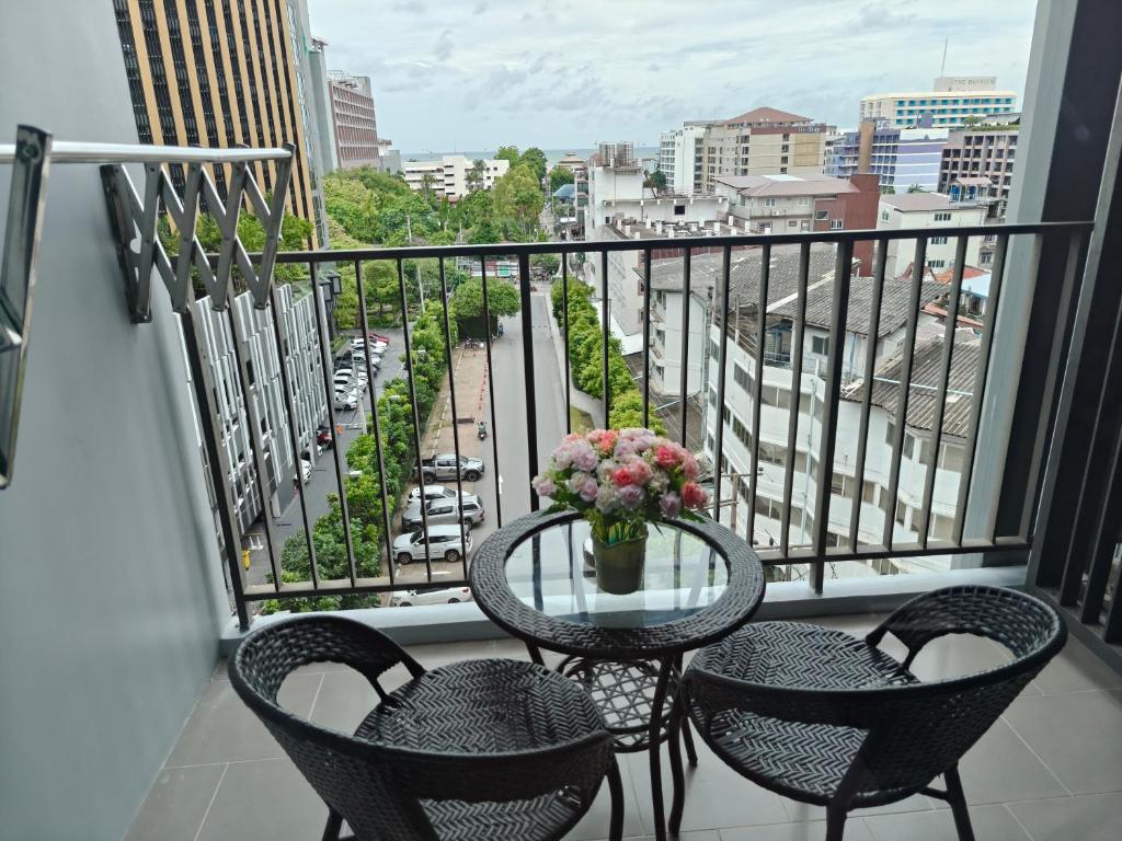 a balcony with two chairs and a table with flowers on it at The base Central Pattaya 2 bedrooms in Pattaya Central