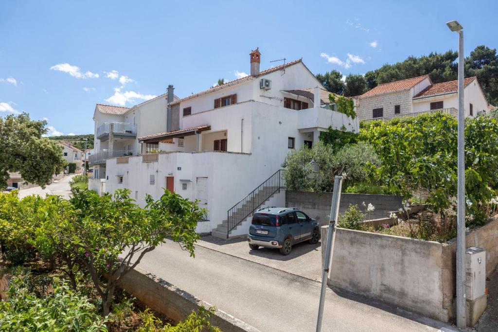 a van parked in front of a white building at Apartments Soni in Postira