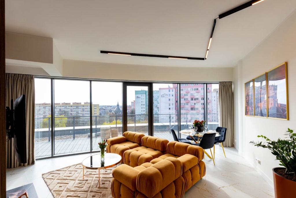 una sala de estar con un sofá y una mesa en Kaleo apartments - Hanza Tower 605, en Szczecin