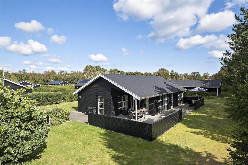 a small black house on a grass field at HA364-Hals-Hou-Mose-19 in Hals