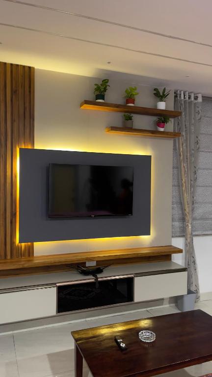 a flat screen tv on a wall in a living room at Elva villa-A luxurious 3bhk home stay near KPHB in Hyderabad