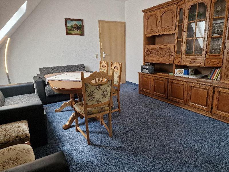 a living room with a table and chairs and a couch at FEWO Torfhaus Holzhau in Rechenberg-Bienenmühle