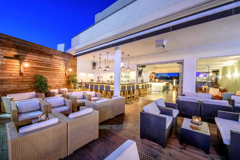 Un restaurante con sofás y mesas y un bar. en Despina Apts by Estia, en Gouves