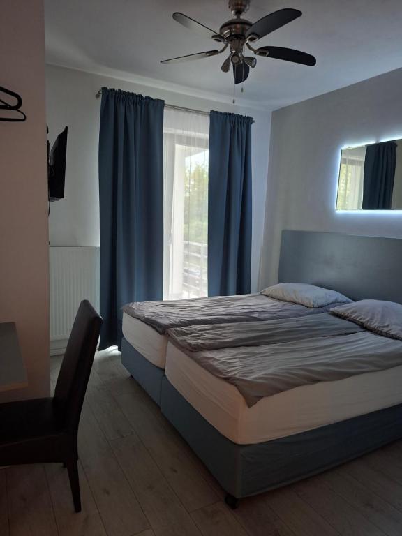 a bedroom with a bed and a ceiling fan at Komfort Noclegi in Blizne Łaszczyńskiego