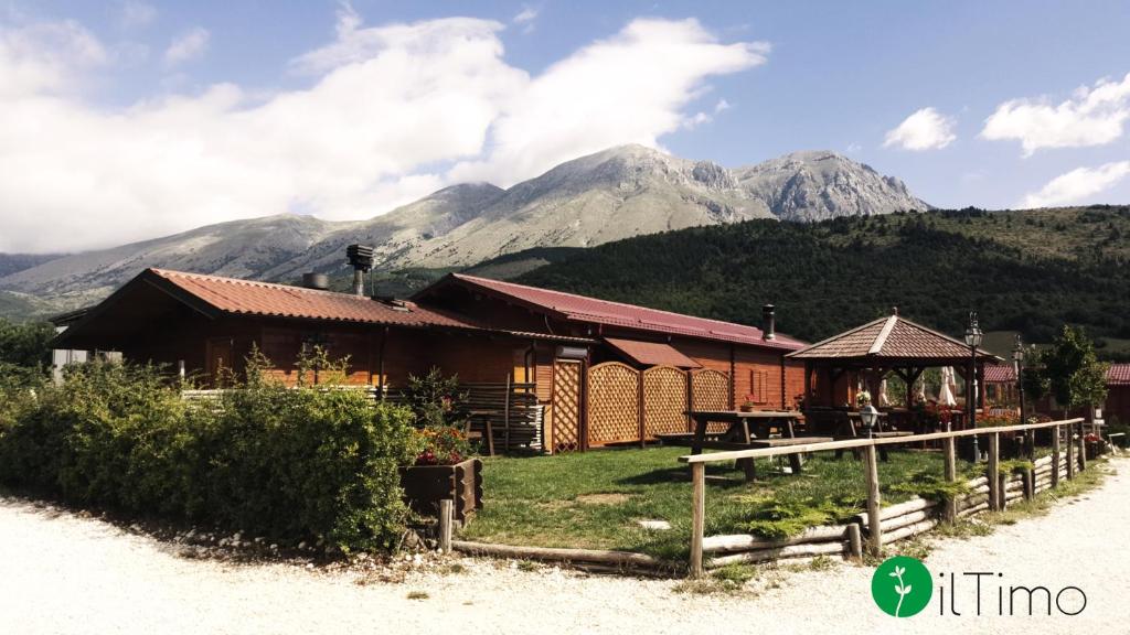 a building with mountains in the background at Agriturismo Il Timo in Magliano deʼ Marsi