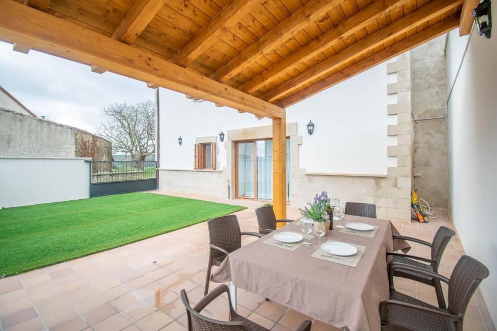 a dining room with a table and chairs on a patio at Amplia casa rural con barbacoa y jardín en Navarra in Olcoz