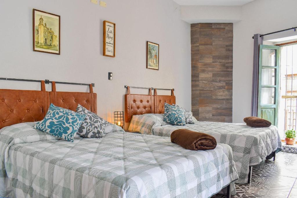 two beds sitting next to each other in a room at Doña Vicenta Casa Colonial in Guanajuato