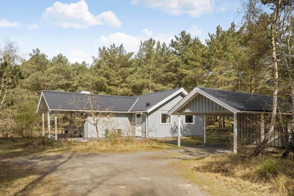 ein weißes Haus mitten im Wald in der Unterkunft 1542 Aakirkeby - Poseregårdsvejen 12 in Vester Sømarken