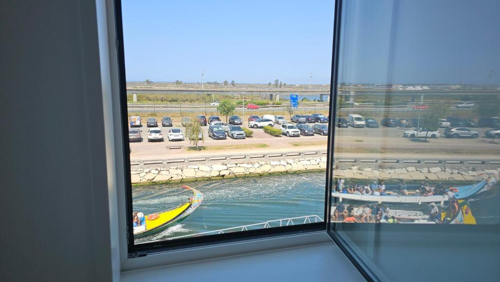 a window with a view of a boat in the water at A Proa do Moliceiro Canal da Ria Lagoon Views in Aveiro